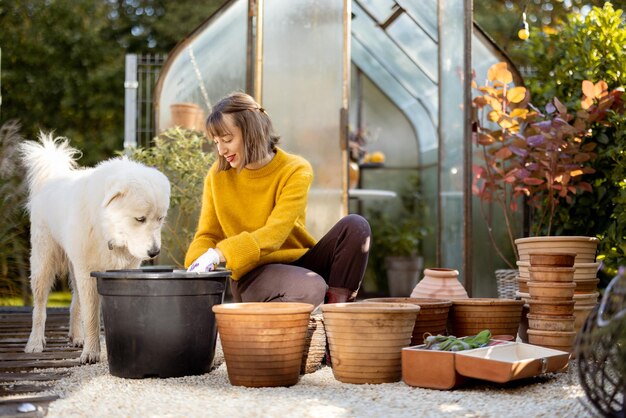 Woman Planting Flowers In Jugs At Garden