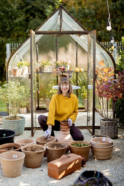 庭で水差しに花を植える女性