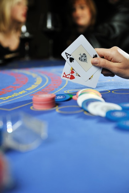 woman play black jack card game in casino on blue table