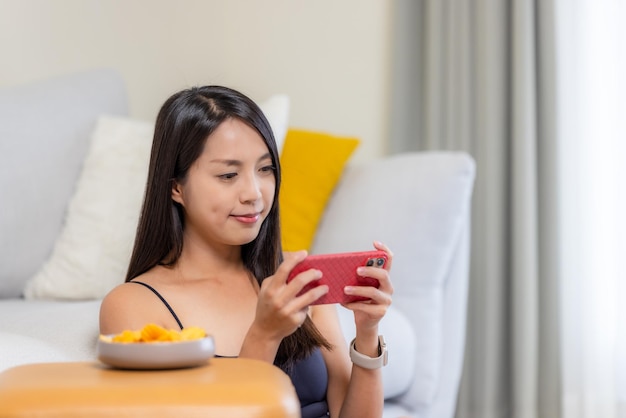 Woman play cellphone game at home