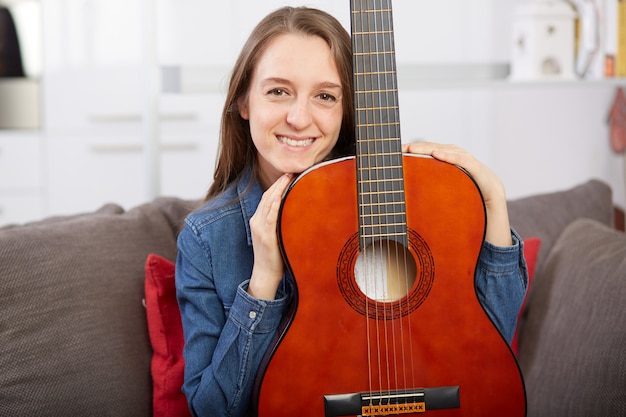 Woman play guitar at home