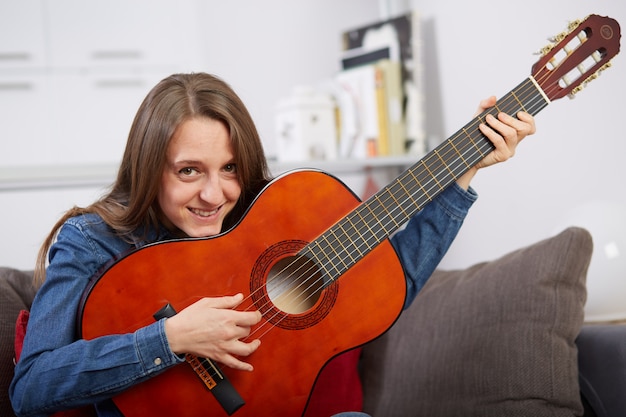 Woman play guitar at home