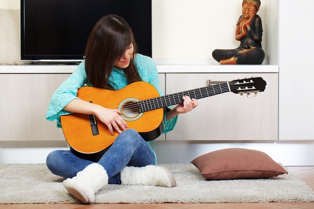 Woman play guitar at home