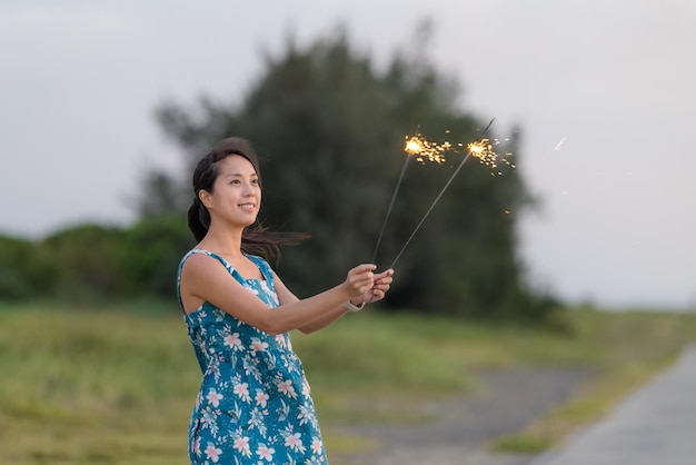 Woman play with beautiful sparkler burning at outdoor