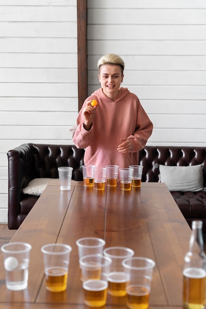 Foto donna che gioca a beer pong a una festa al coperto