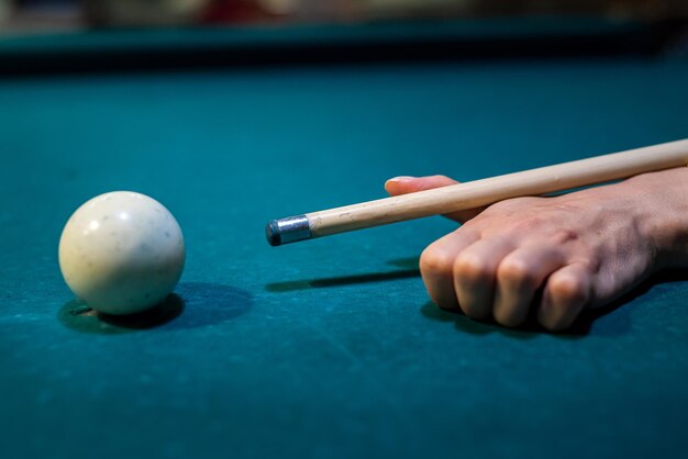 Woman playing billiard, close up of player take a shot