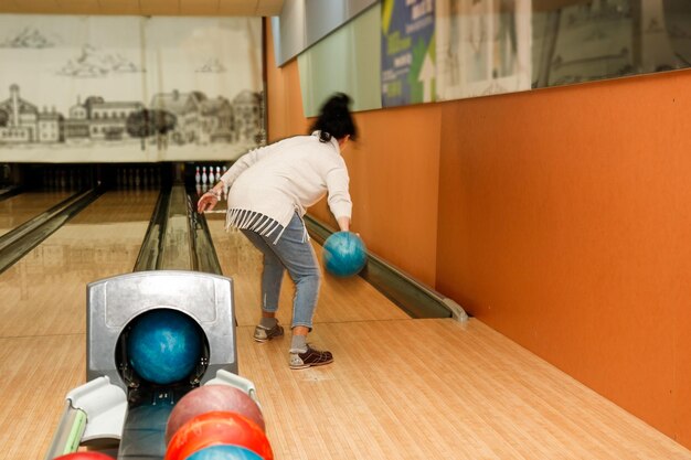 woman playing bowling rear view