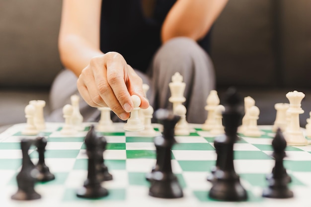 Photo woman playing chess board game at home