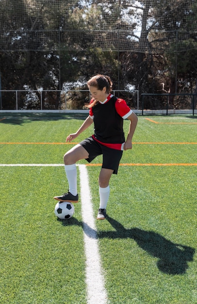 Photo woman playing football full shot