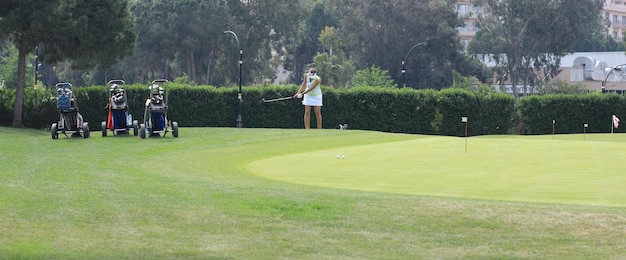 woman playing golf on green field