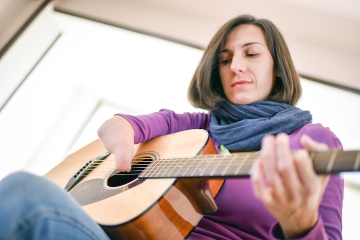 Photo woman playing guitar at home