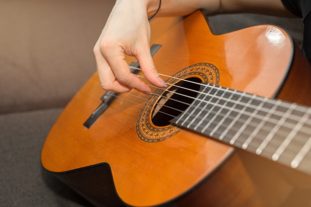 woman playing guitar at home