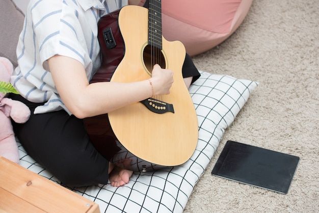 woman playing guitar with tablet