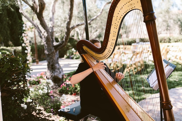 Woman playing a harp outdoors