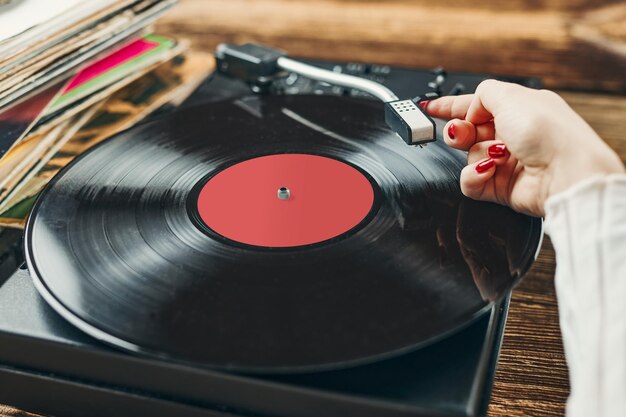 Woman playing music from vinyl record analog record retro and vintage style analog sound music