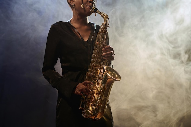 Foto donna che suona il sassofono in un club di musica jazz