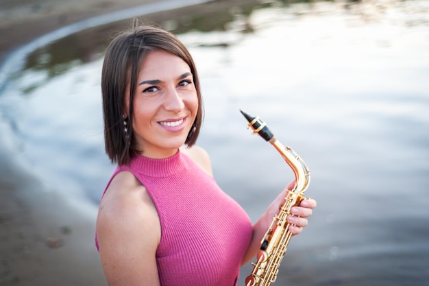 Woman playing the saxophone at sunset