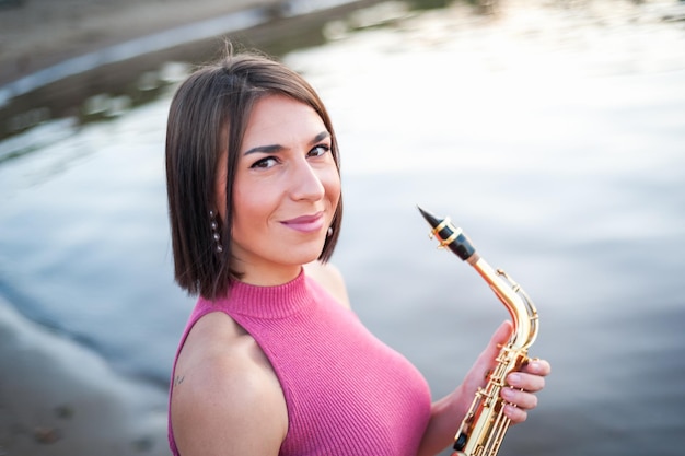 Woman playing the saxophone at sunset