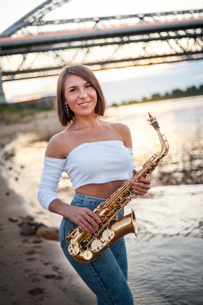 Woman playing the saxophone at sunset