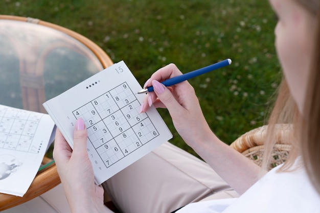 Photo woman playing a sudoku game alone