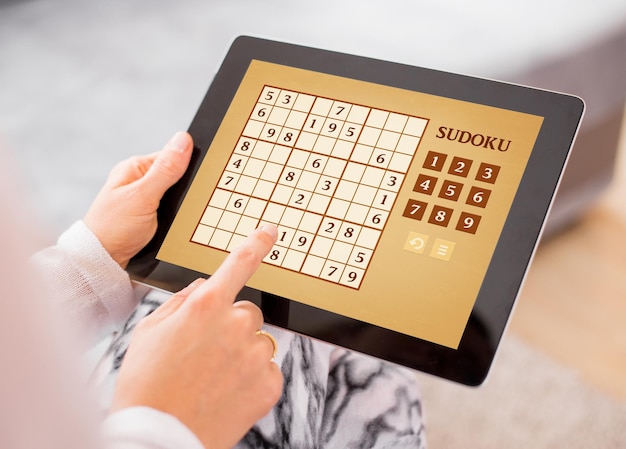 Woman playing Sudoku on tablet computer