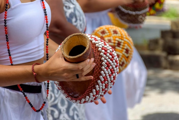 Foto donna che suona un tipo di sonagli chiamato xereque di origine africana usato per le strade del brasile