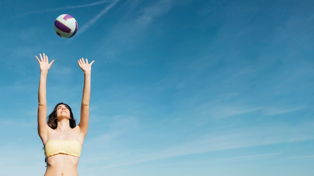 Foto donna che gioca a pallavolo in spiaggia