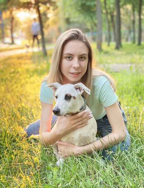 Woman playing with a dog breed Jack Russell Terrier