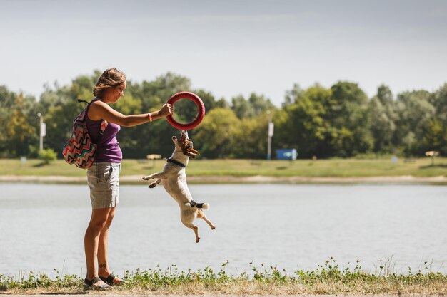 写真 自然の中で犬と遊ぶ女性