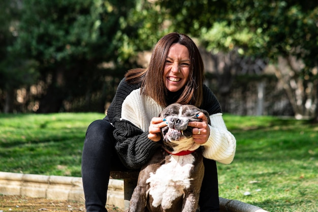 Photo woman playing with dog in park