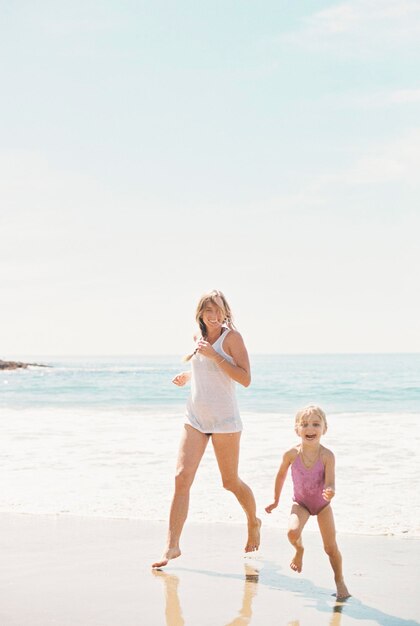 Woman playing with her daughter on a sandy beach