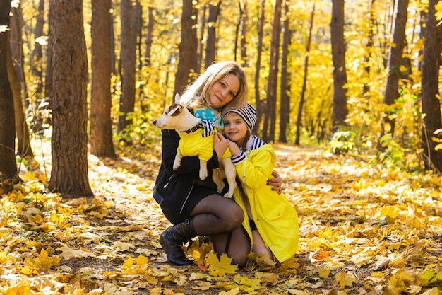 Woman playing with her dog at autumn park