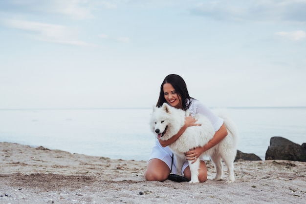 ビーチで彼女の犬と遊ぶ女性