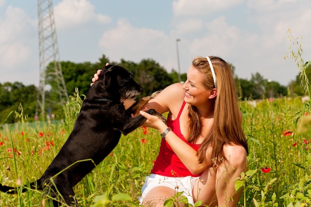 Woman playing with her dog in a meadow