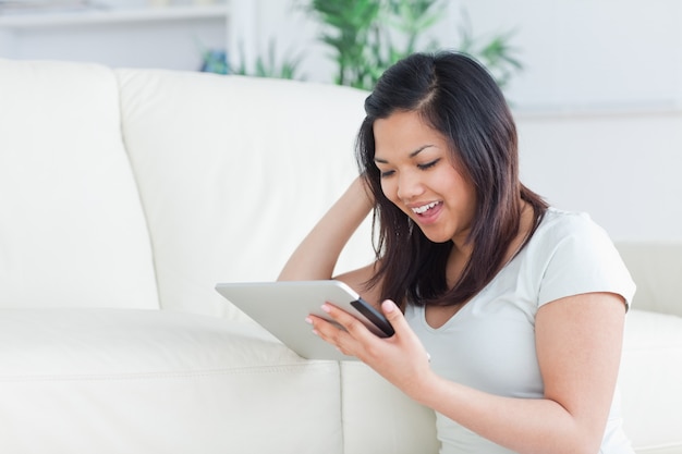 Woman playing with a tactile tablet while sitting on the floor