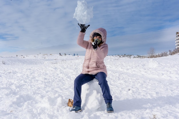 写真 冬の日にアウトドアを楽しみながら雪遊びをする女性