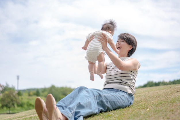 A woman plays with a baby on a hill