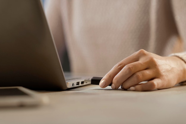 woman plugging a usb drive into her laptop technology and data storage concept