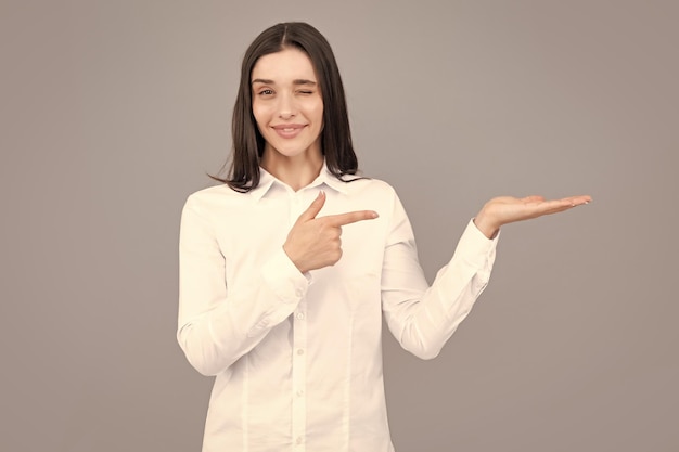 Woman point at copy space showing copyspace pointing Promo girl showing advertisement content gesture pointing with hand recommend product Isolated background