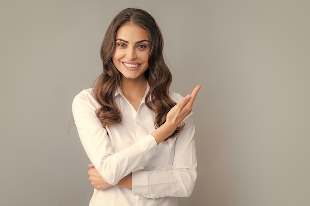 Woman point at copy space showing copyspace pointing Promo girl showing advertisement content gesture pointing with hand recommend product Isolated grey background