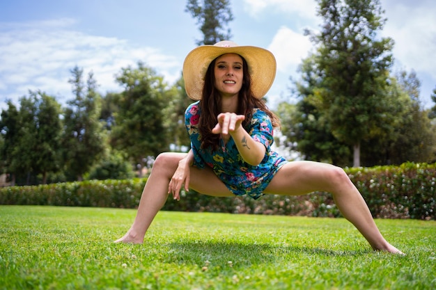 Woman pointing ahead while dancing freestyle in a garden