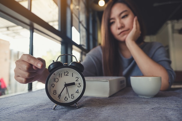 woman pointing at alarm clock