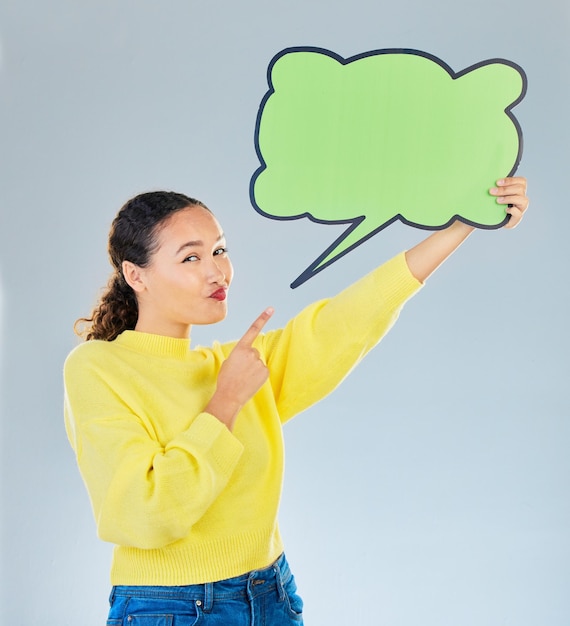 Woman pointing and speech bubble portrait for question social media or faq communication Young female model with a sign or space for marketing idea or opinion on a white studio background