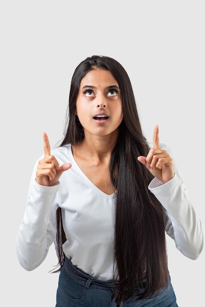 A woman pointing up with her fingers up and a white background