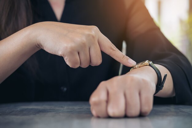 woman pointing at a watch