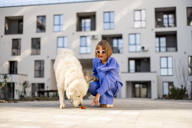 Woman points finger on dogs poop walking with pet