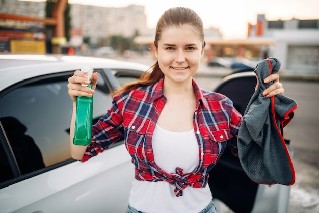 Photo woman polishes car after washing on car-wash