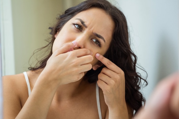 Woman popping her pimple