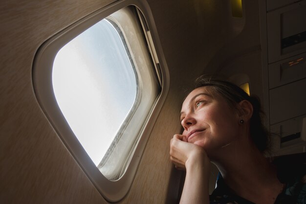 Photo woman at porthole in plane