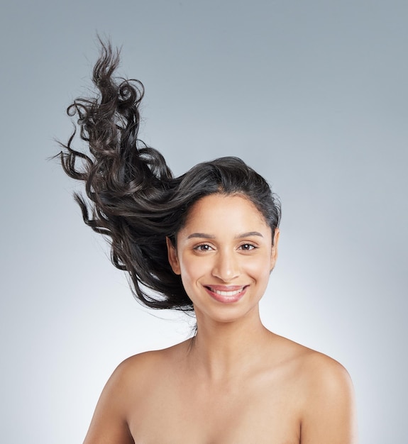 Woman portrait and air or hair care in studio beauty and texture shampoo on white background Female person cosmetics and conditioner treatment for hairstyle confident and smile for dermatology